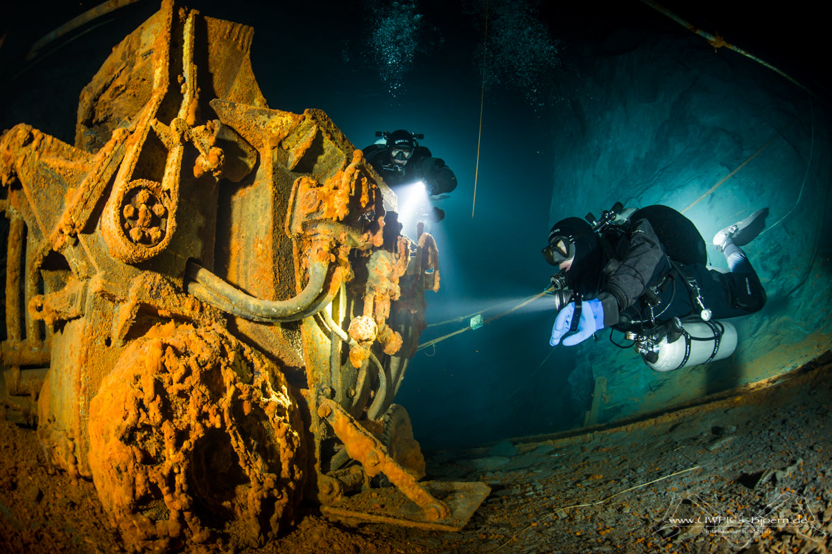 diver swimming around engine room in sunken wreck